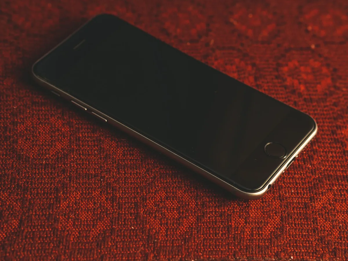 smartfon leżący na teksturowanej czerwonej tkaninie — Motorola Moto G13 w zgłoszeniu — jak odpowiadamy i co radzimy