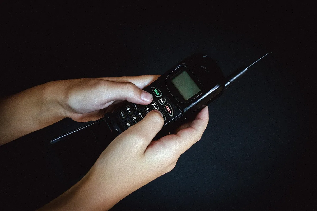 dłonie trzymające retro telefon komórkowy z lat 90 — Motorola Moto G7 Power — czego przy tym sprzęcie nie zrobimy
