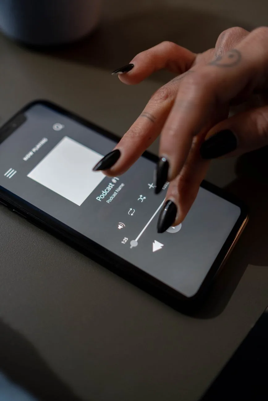 wytatuowana dłoń obsługująca podcast na ekranie smartfona — Motorola Moto G8 w zgłoszeniu — jak odpowiadamy i co radzimy