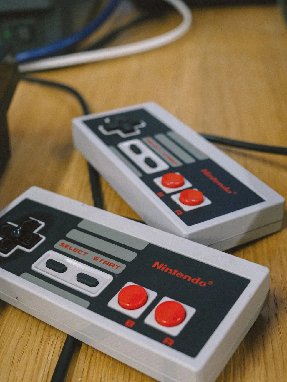 klasyczne kontrolery Nintendo na drewnianym stole — Nintendo Switch OLED a zakres naszego serwisu — czym zajmujemy się zamiast