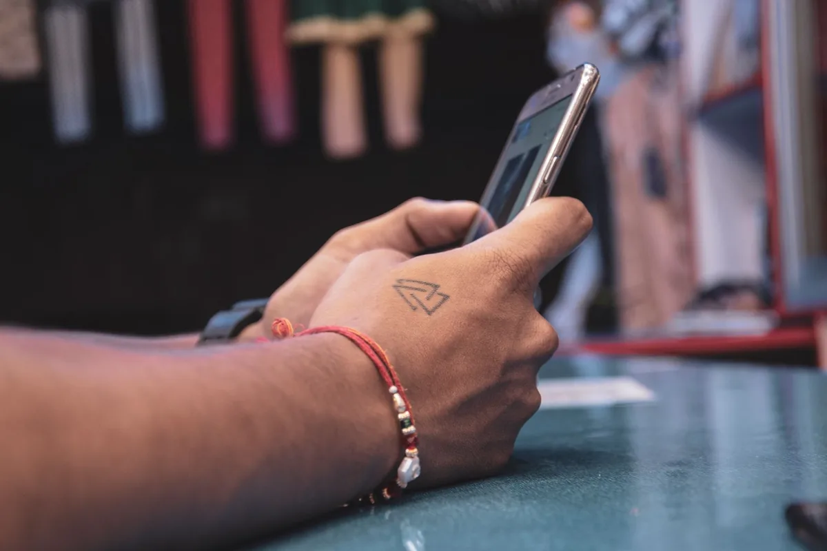 wytatuowana dłoń trzymająca smartfon we wnętrzu — Nokia 106 w zgłoszeniu — jak odpowiadamy i co radzimy