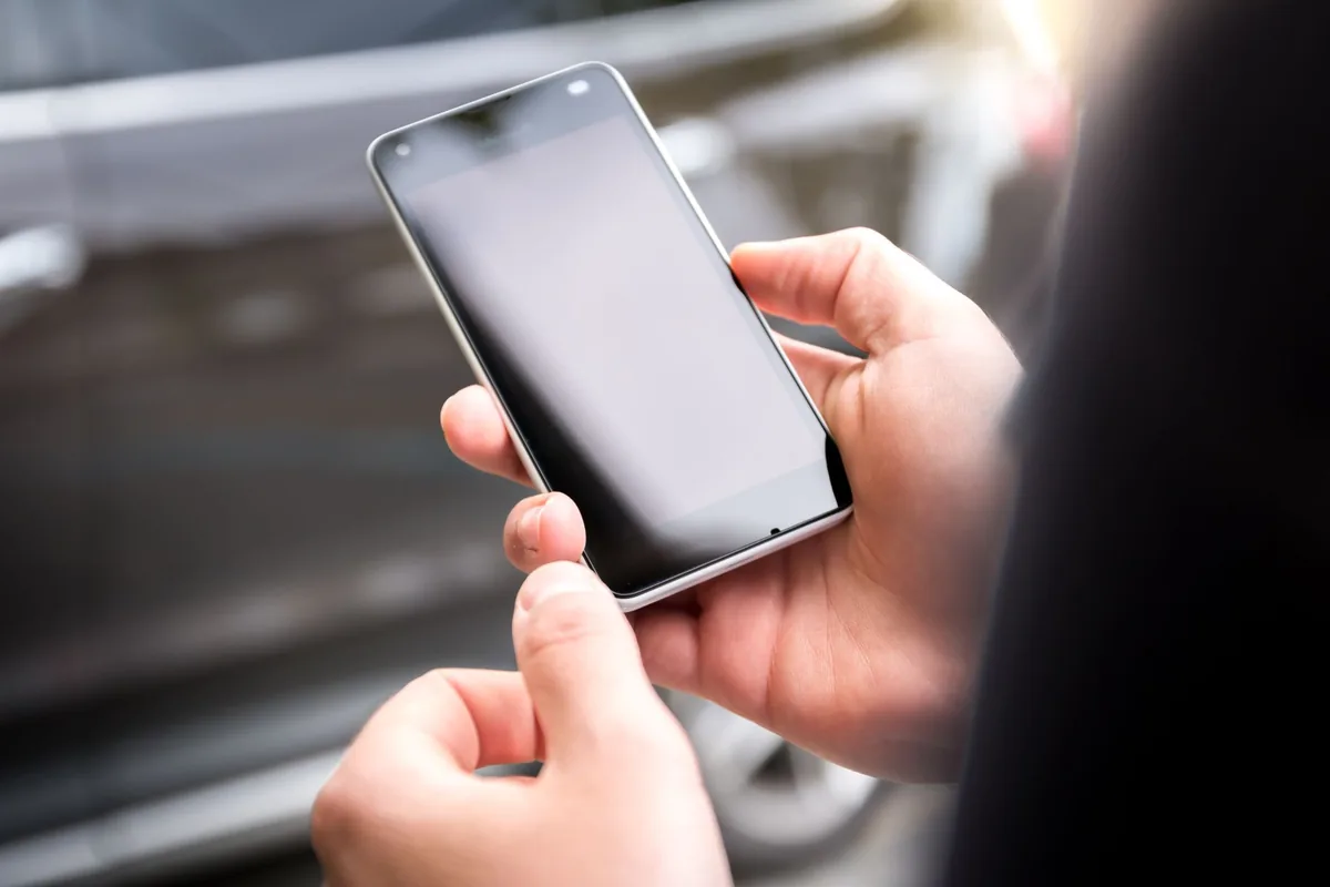 dłonie trzymające nowoczesny smartfon w świetle dziennym — Nokia C21 w zgłoszeniu — jak odpowiadamy i co radzimy
