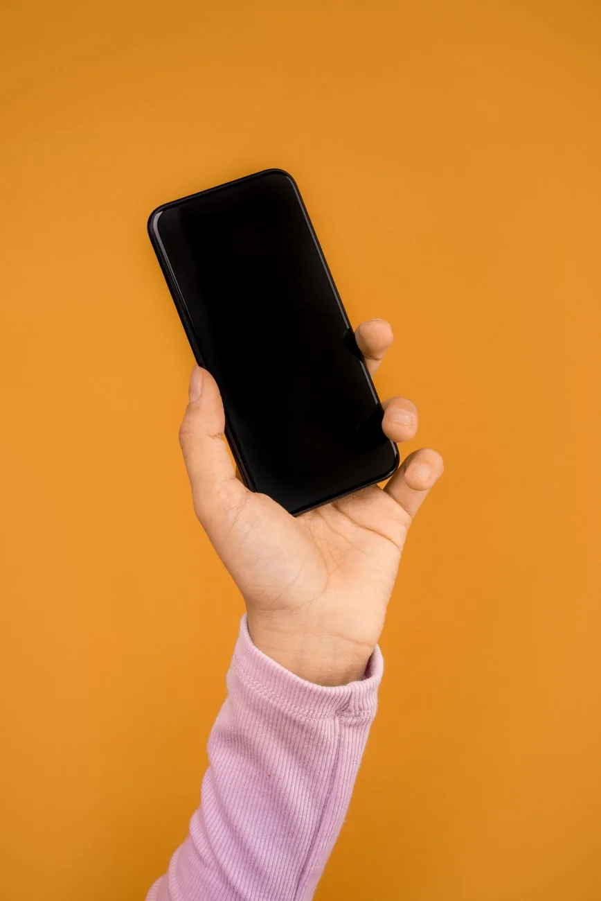dłoń trzymająca smartfon na jaskrawym pomarańczowym tle — Nokia G42 poza naszym warsztatem — gdzie szukać pomocy