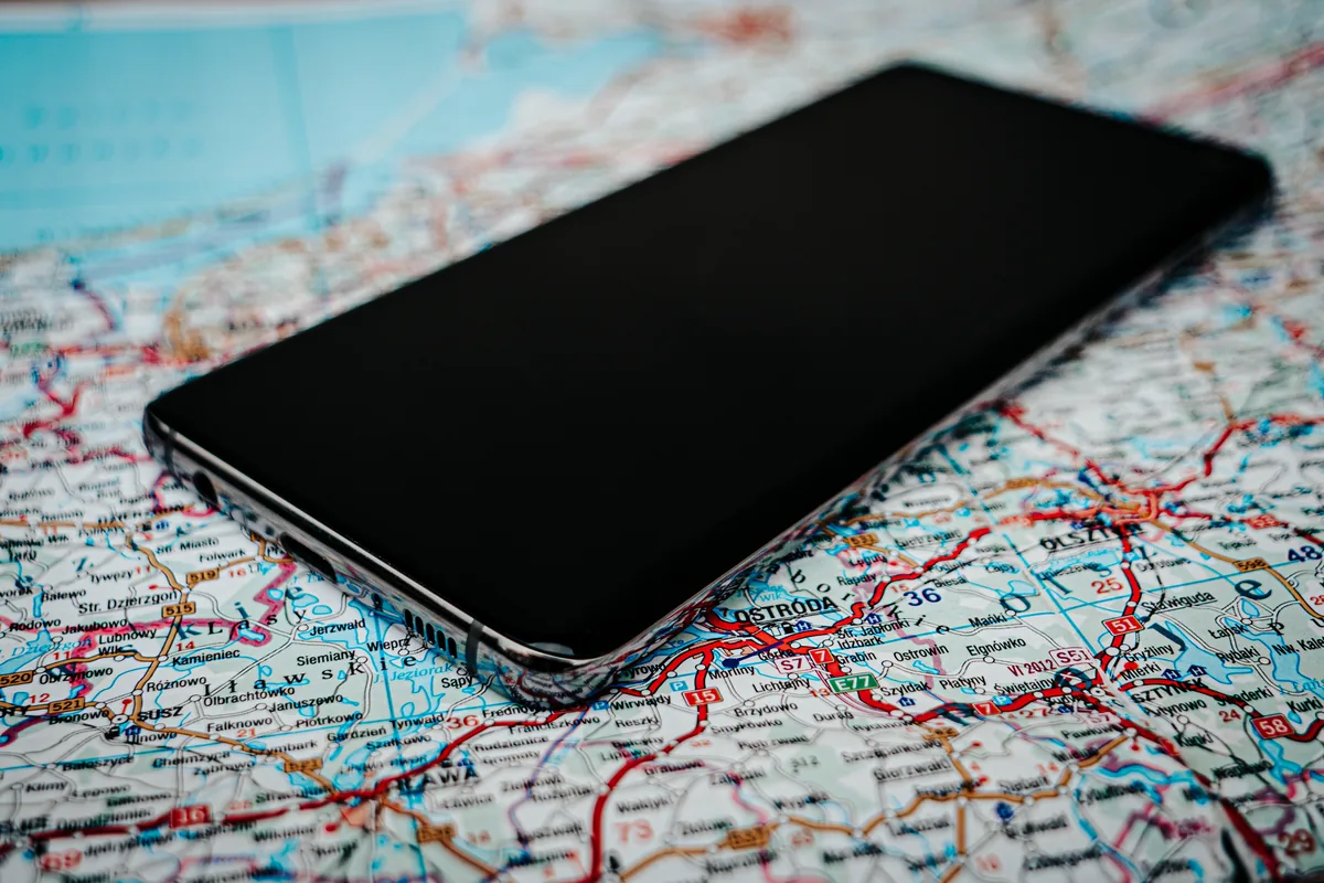 smartfon leżący na szczegółowej mapie drogowej polski — OnePlus 7T poza naszym warsztatem — gdzie szukać pomocy