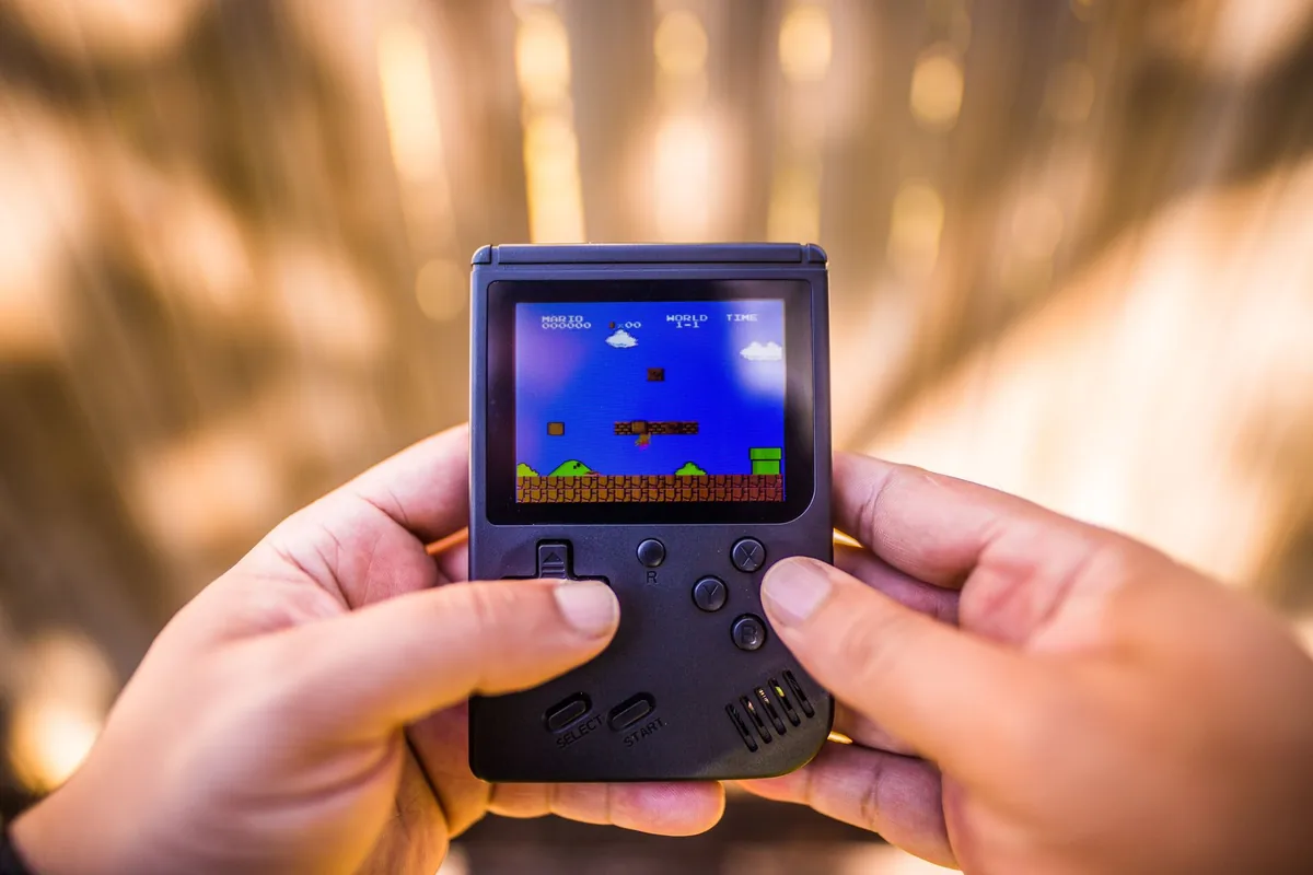 dłonie trzymające konsolę retro z włączoną grą — OneXPlayer 2 w zgłoszeniu — jak odpowiadamy i co radzimy