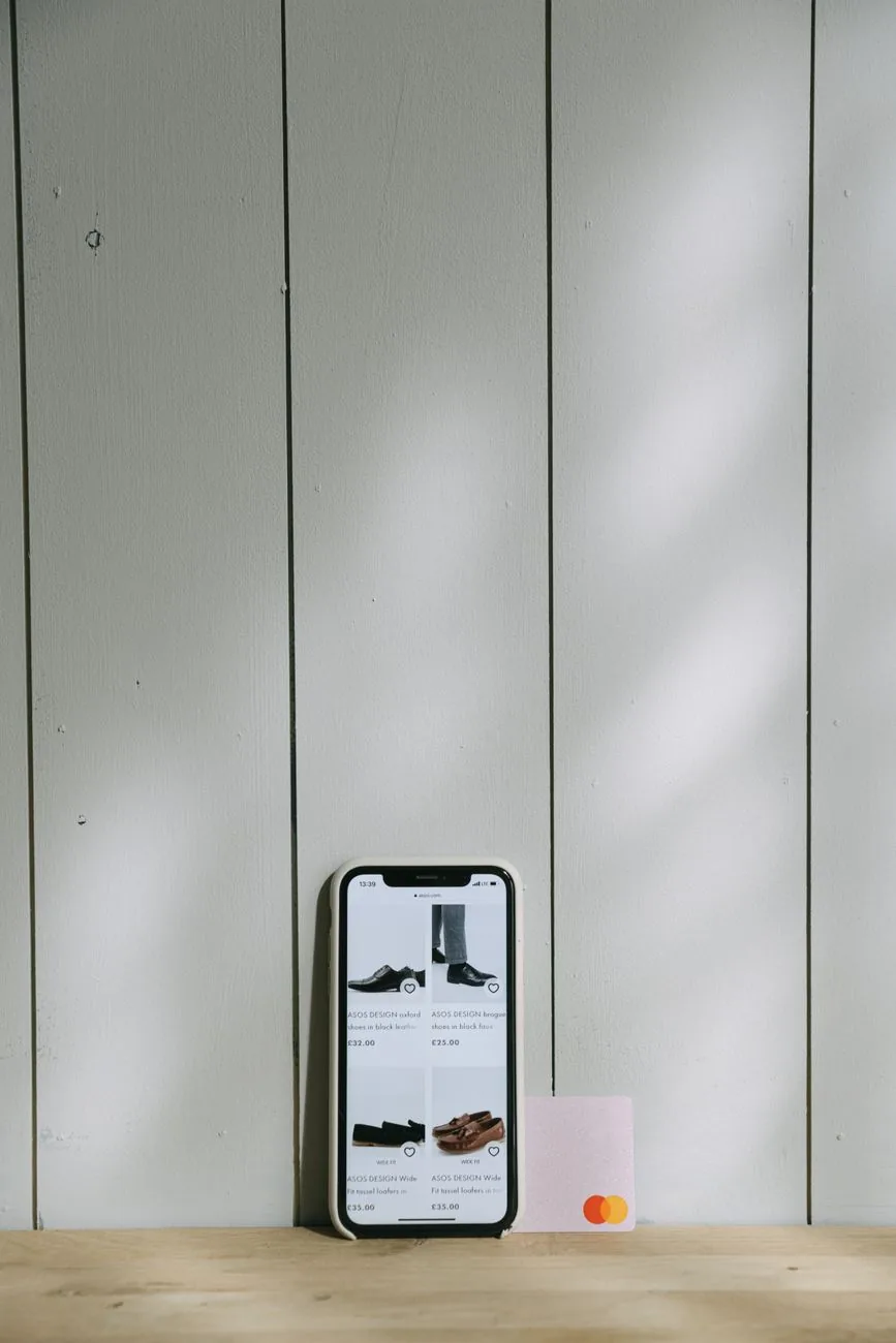 smartfon z aplikacją zakupową obok karty płatniczej na drewnianym stole — OPPO A38 a zakres naszego serwisu — czym zajmujemy się zamiast
