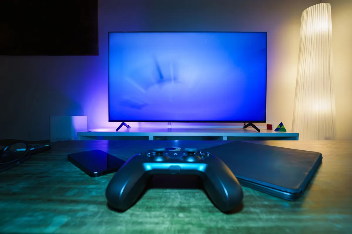 telewizor z kontrolerem do gier w oświetlonym salonie — Philips Ambilight PUS8108 poza naszym warsztatem — gdzie szukać pomocy