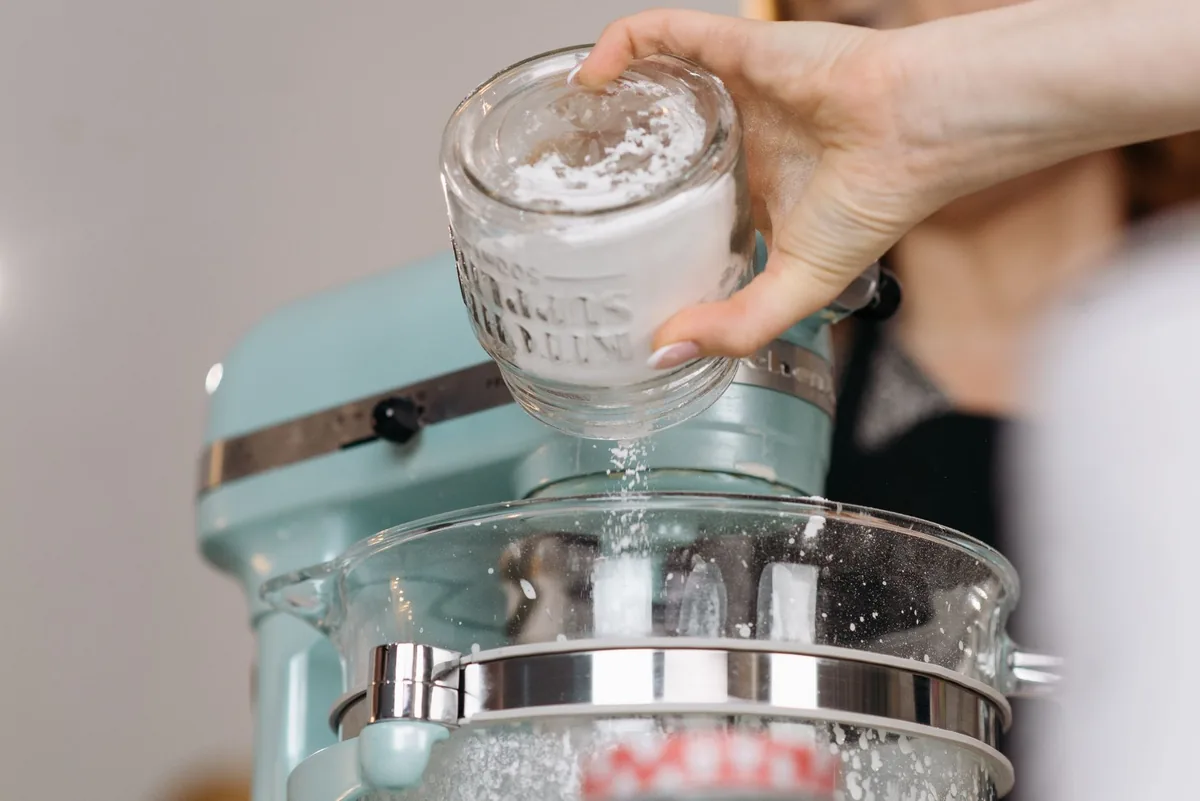 dłoń wsypująca mąkę do misy miksera — Philips HomeCooker a zakres naszego serwisu — czym zajmujemy się zamiast