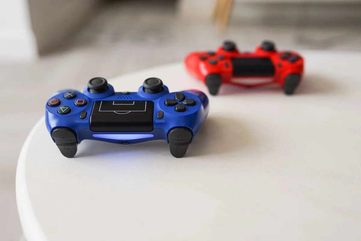 kontrolery do konsoli PlayStation na białym stole — PlayStation 5 — czego przy tym sprzęcie nie zrobimy