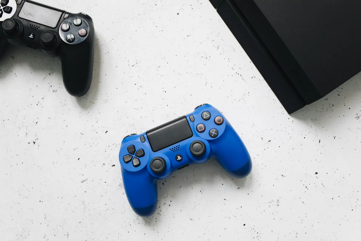 niebieski i czarny kontroler z konsolą PlayStation na białej powierzchni — PlayStation 5 z napędem w zgłoszeniu — jak odpowiadamy i co radzimy