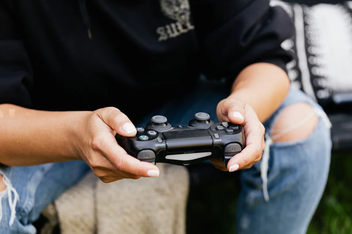 dłonie trzymające kontroler do gier w pokoju — PlayStation VR2 Sense poza naszym warsztatem — gdzie szukać pomocy