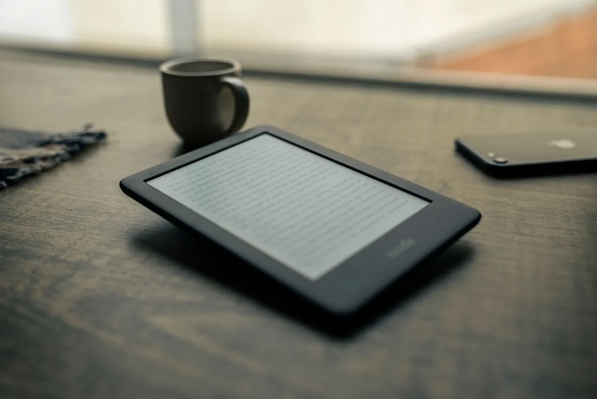czytnik e-booków z kubkiem na drewnianym stole — PocketBook Era Color — czego przy tym sprzęcie nie zrobimy