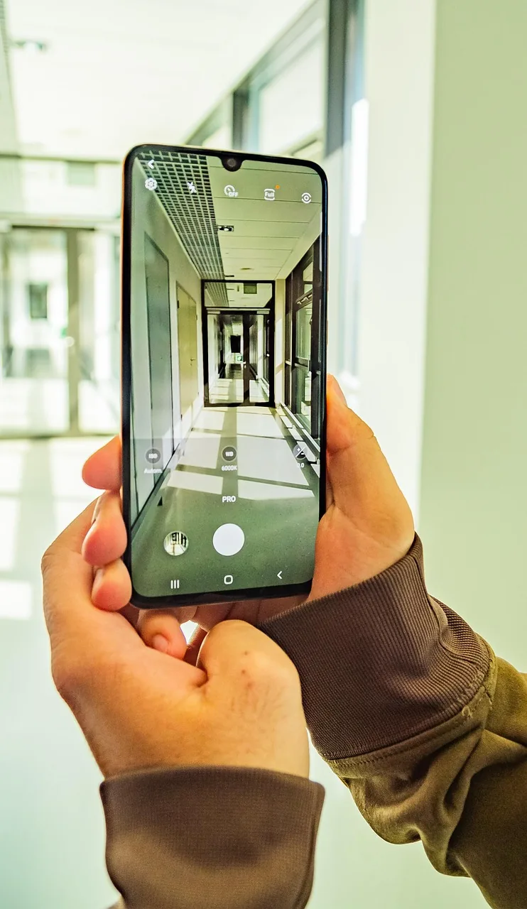 smartfon w korytarzu podczas robienia zdjęć — POCO F7 poza naszym warsztatem — gdzie szukać pomocy