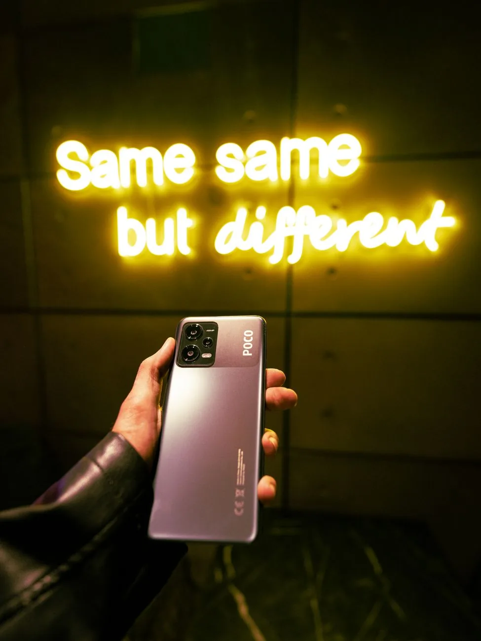 dłoń trzymająca smartfon Poco na tle neonowego napisu — POCO X6 Pro a zakres naszego serwisu — czym zajmujemy się zamiast