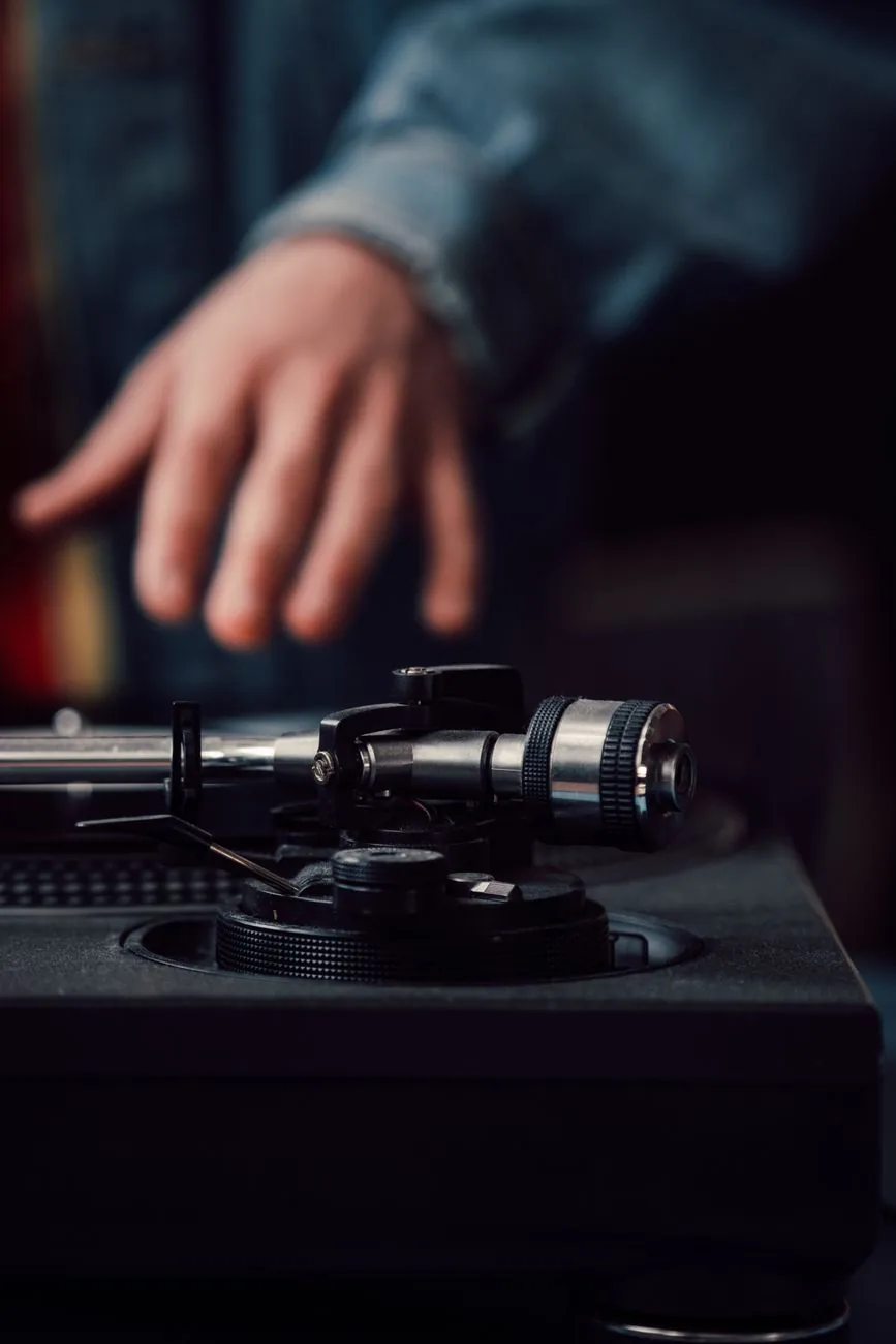 zbliżenie na gramofon i dłoń nad płytą winylową — Pro-Ject Debut Carbon EVO w zgłoszeniu — jak odpowiadamy i co radzimy