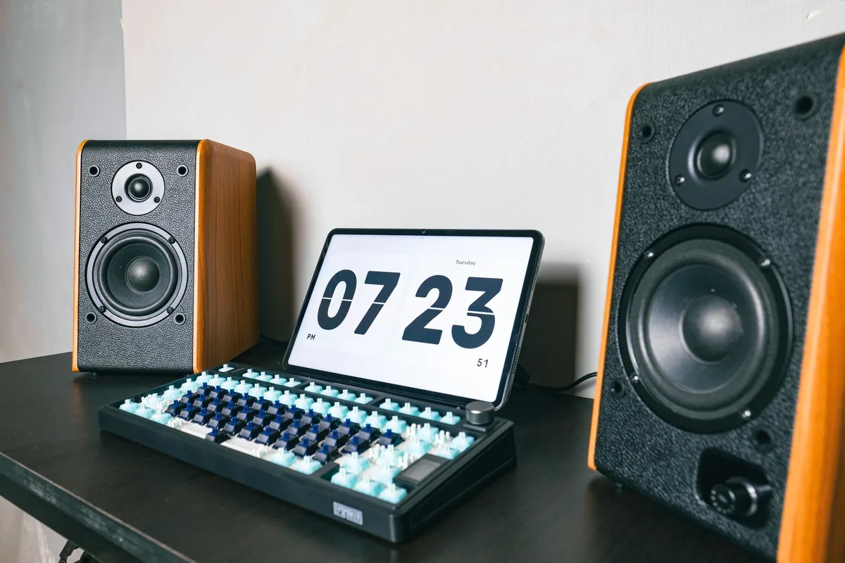 drewniane kolumny głośnikowe, tablet i klawiatura na biurku — Q Acoustics 3020i — czego przy tym sprzęcie nie zrobimy