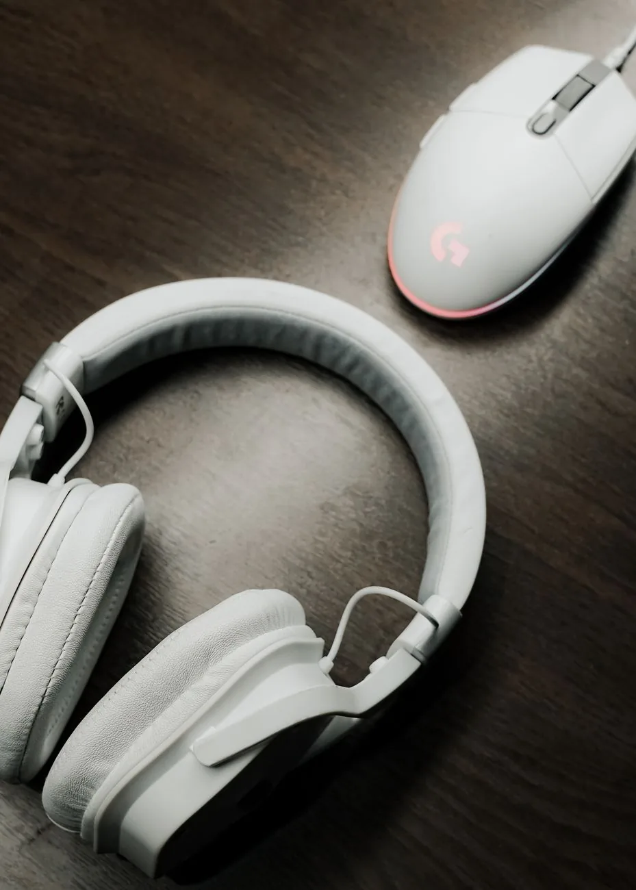białe słuchawki i mysz komputerowa na drewnianym stole — Razer Kraken Tournament Edition poza naszym warsztatem — gdzie szukać pomocy