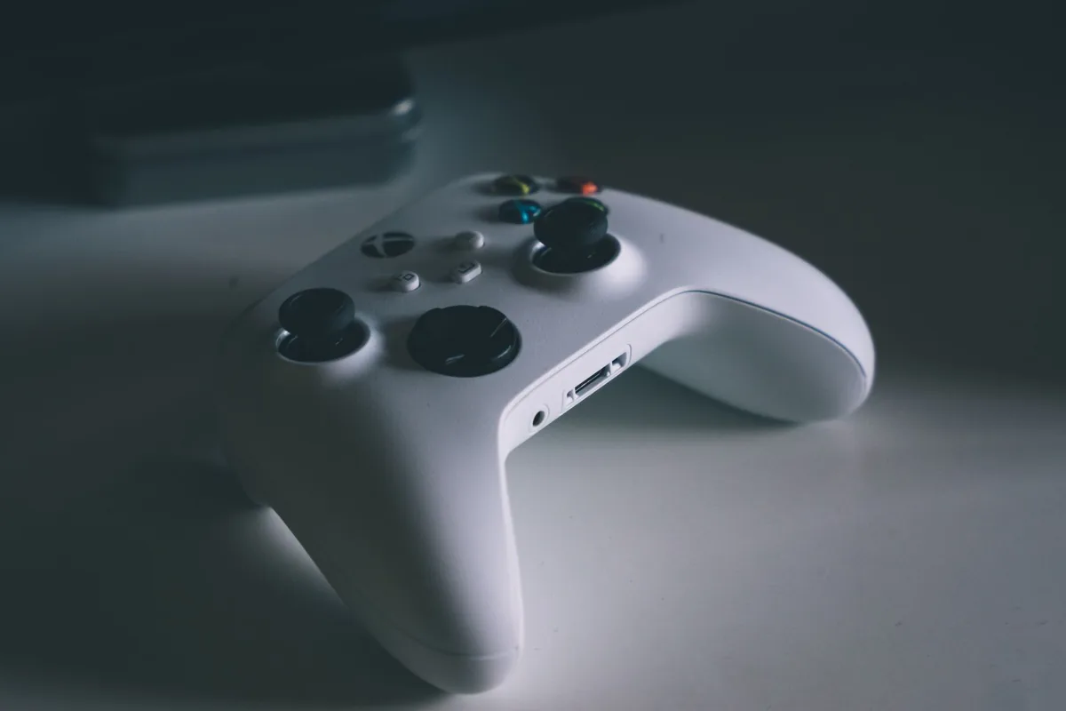 biały kontroler do gier leżący na biurku — Razer Wolverine V2 a zakres naszego serwisu — czym zajmujemy się zamiast