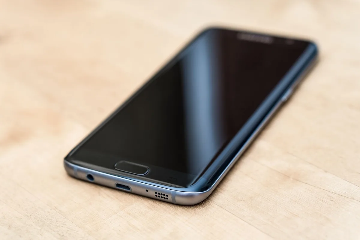 nowoczesny elegancki smartfon leżący na drewnianej powierzchni — realme C21 w zgłoszeniu — jak odpowiadamy i co radzimy