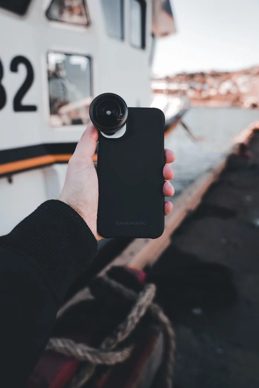 dłoń ze smartfonem i obiektywem przy pomoście — realme C30 — czego przy tym sprzęcie nie zrobimy