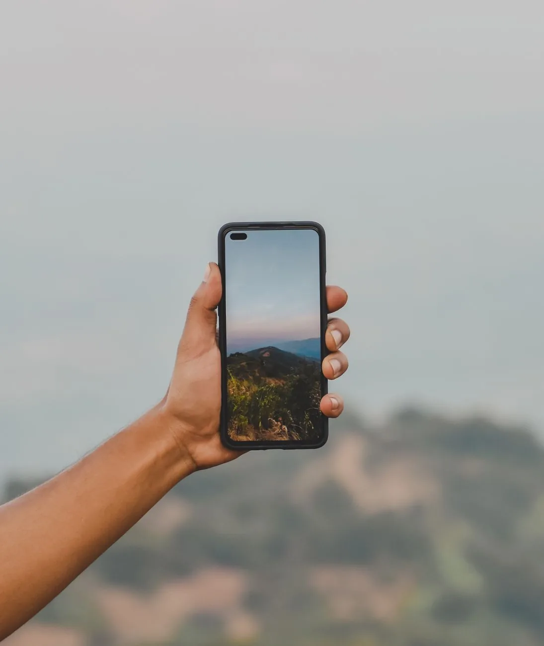 dłoń trzymająca smartfon z górskim krajobrazem — Redmi 8 w zgłoszeniu — jak odpowiadamy i co radzimy