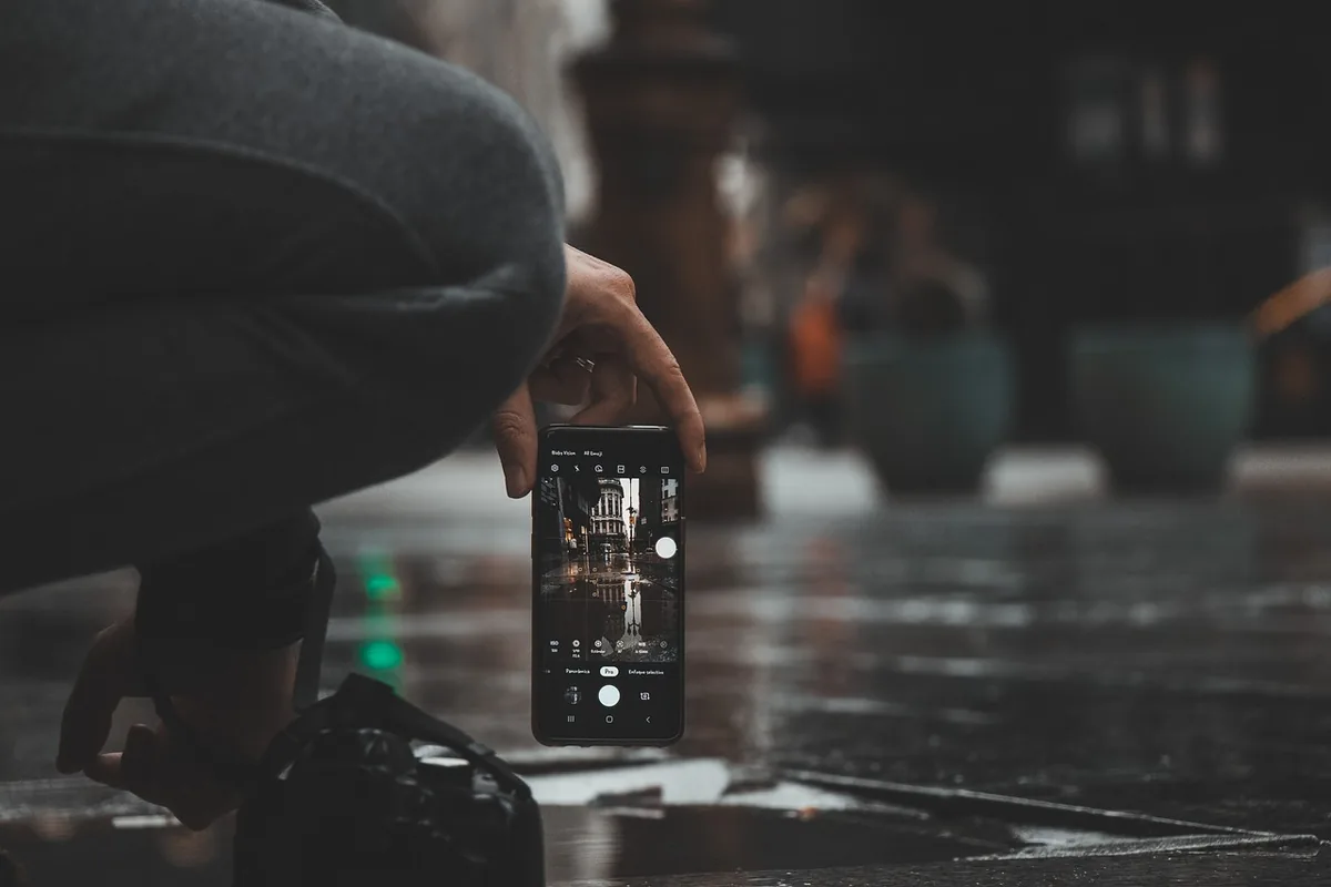 dłoń trzymająca smartfon podczas deszczu — Redmi Note 13 5G poza naszym warsztatem — gdzie szukać pomocy