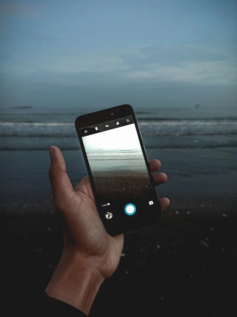 dłoń ze smartfonem na tle oceanu — Samsung Galaxy A16 a zakres naszego serwisu — czym zajmujemy się zamiast