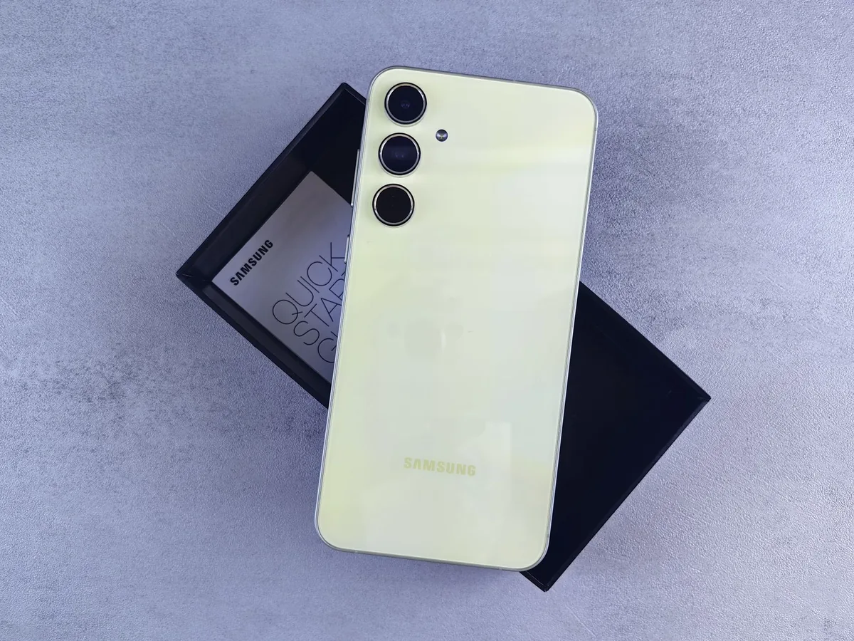żółty smartfon Samsung na szarej powierzchni z pudełkiem i instrukcją — Samsung Galaxy A40 poza naszym warsztatem — gdzie szukać pomocy