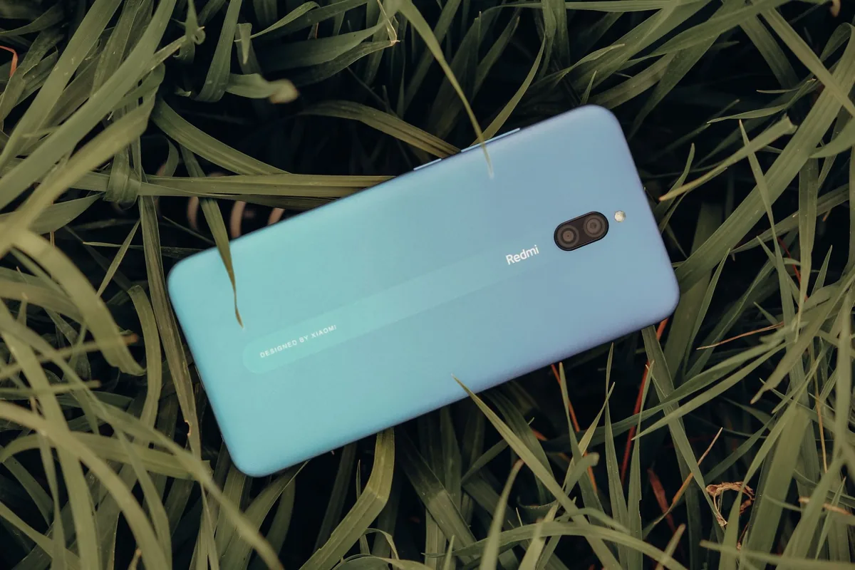 niebieski smartfon leżący na soczyście zielonej trawie — Samsung Galaxy S23+ a zakres naszego serwisu — czym zajmujemy się zamiast