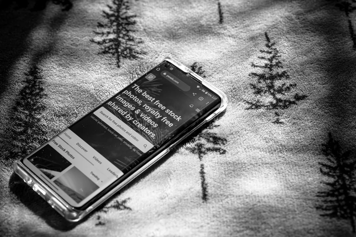 smartfon leżący na tkaninie z motywem drzew — Samsung Galaxy Xcover Pro w zgłoszeniu — jak odpowiadamy i co radzimy