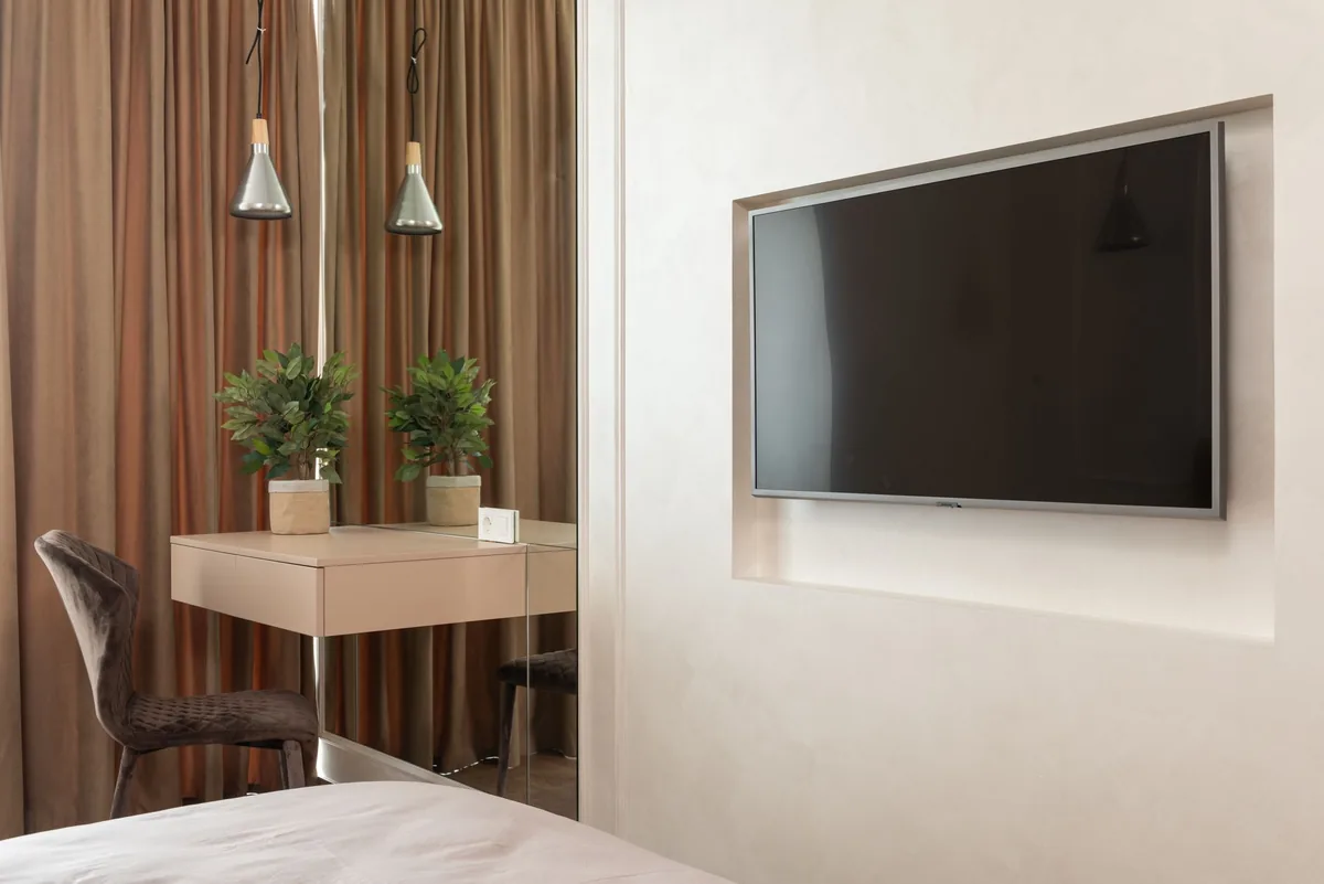 telewizor na ścianie w pokoju hotelowym obok lustra — Samsung QLED Q70D — czego przy tym sprzęcie nie zrobimy