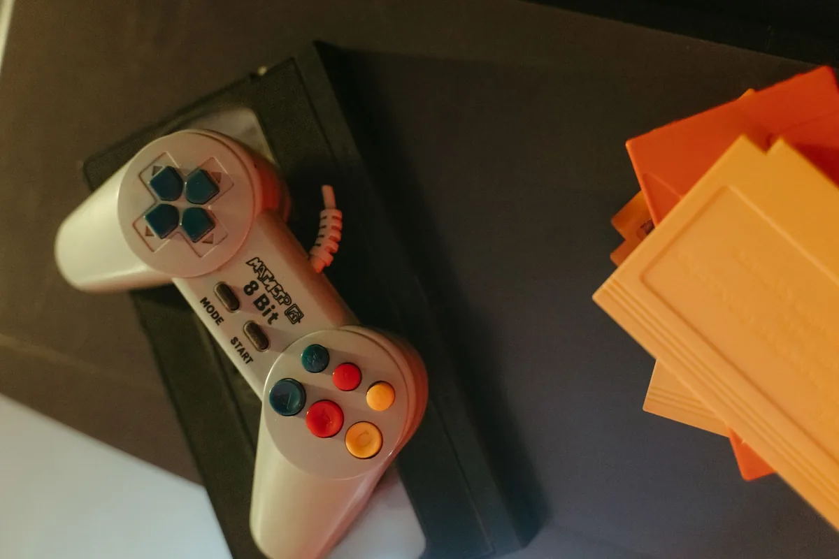 ośmiobitowy kontroler retro obok kartridży z grami — SEGA Dreamcast poza naszym warsztatem — gdzie szukać pomocy