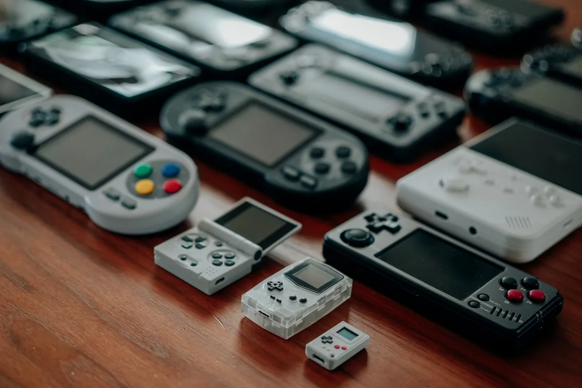 kolekcja przenośnych konsol retro na drewnianej powierzchni — SEGA Mega Drive Mini 2 w zgłoszeniu — jak odpowiadamy i co radzimy
