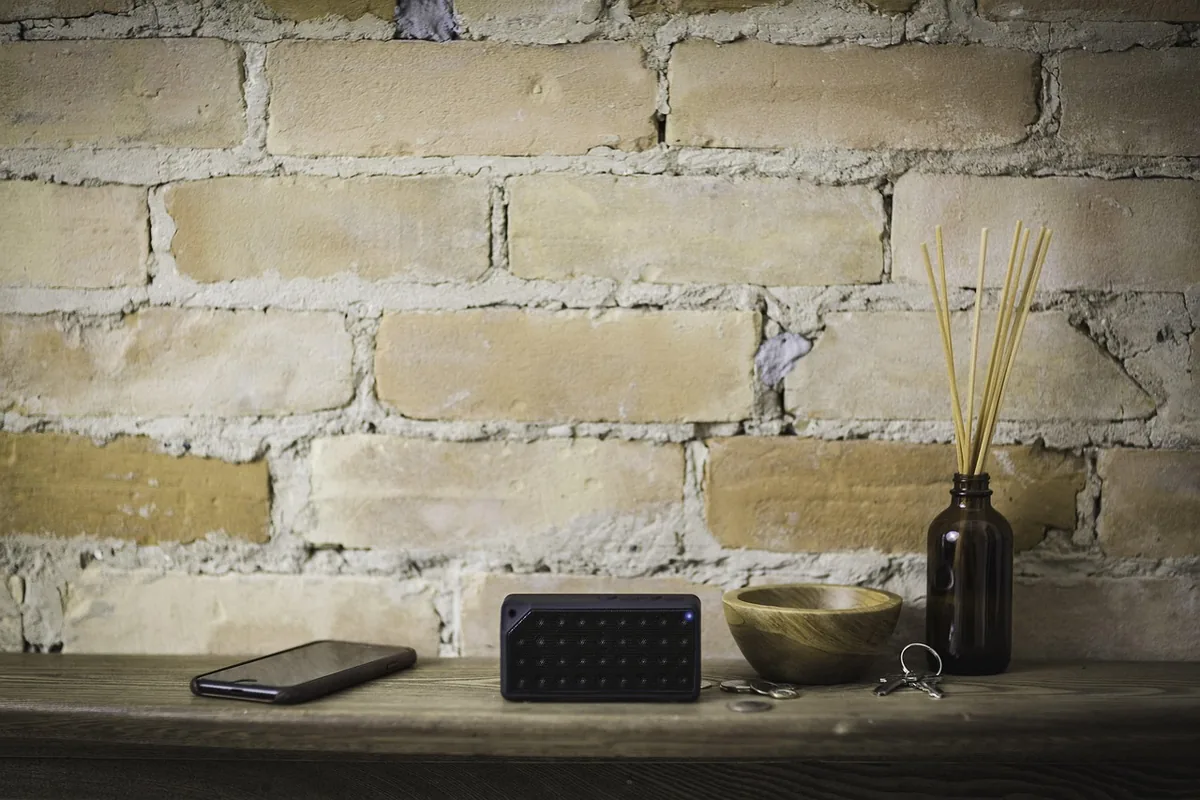 czarny głośnik bezprzewodowy na brązowym stoliku — Sonos Playbase w zgłoszeniu — jak odpowiadamy i co radzimy