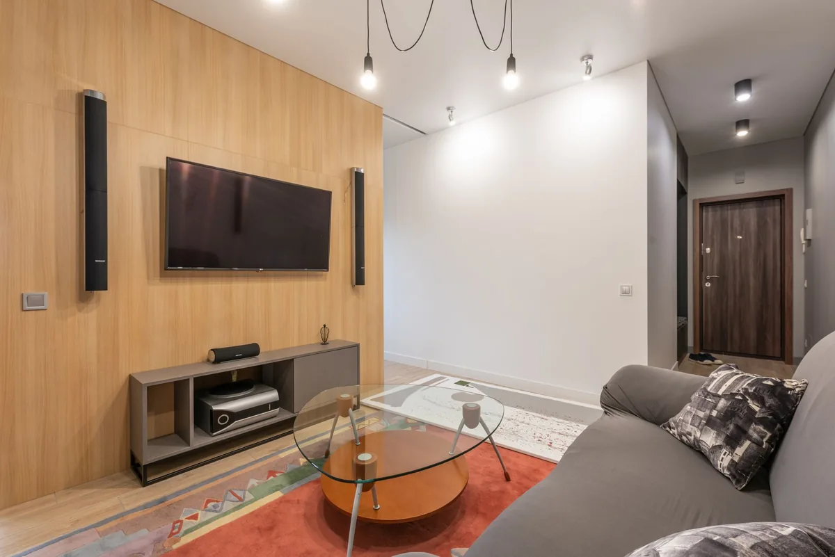 telewizor na ścianie w jasnym salonie z kanapą — Sony BRAVIA X75WL — czego przy tym sprzęcie nie zrobimy