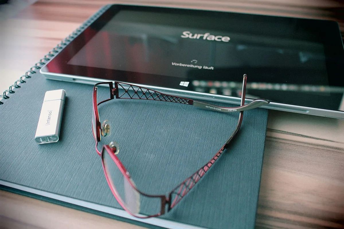 tablet, okulary i pamięć USB na zorganizowanym biurku — Surface Pro 2 — czego przy tym sprzęcie nie zrobimy