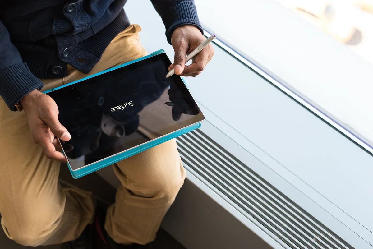 tablet trzymany w dłoniach przy oknie biurowym — Surface Pro (pierwsza generacja) w zgłoszeniu — jak odpowiadamy i co radzimy