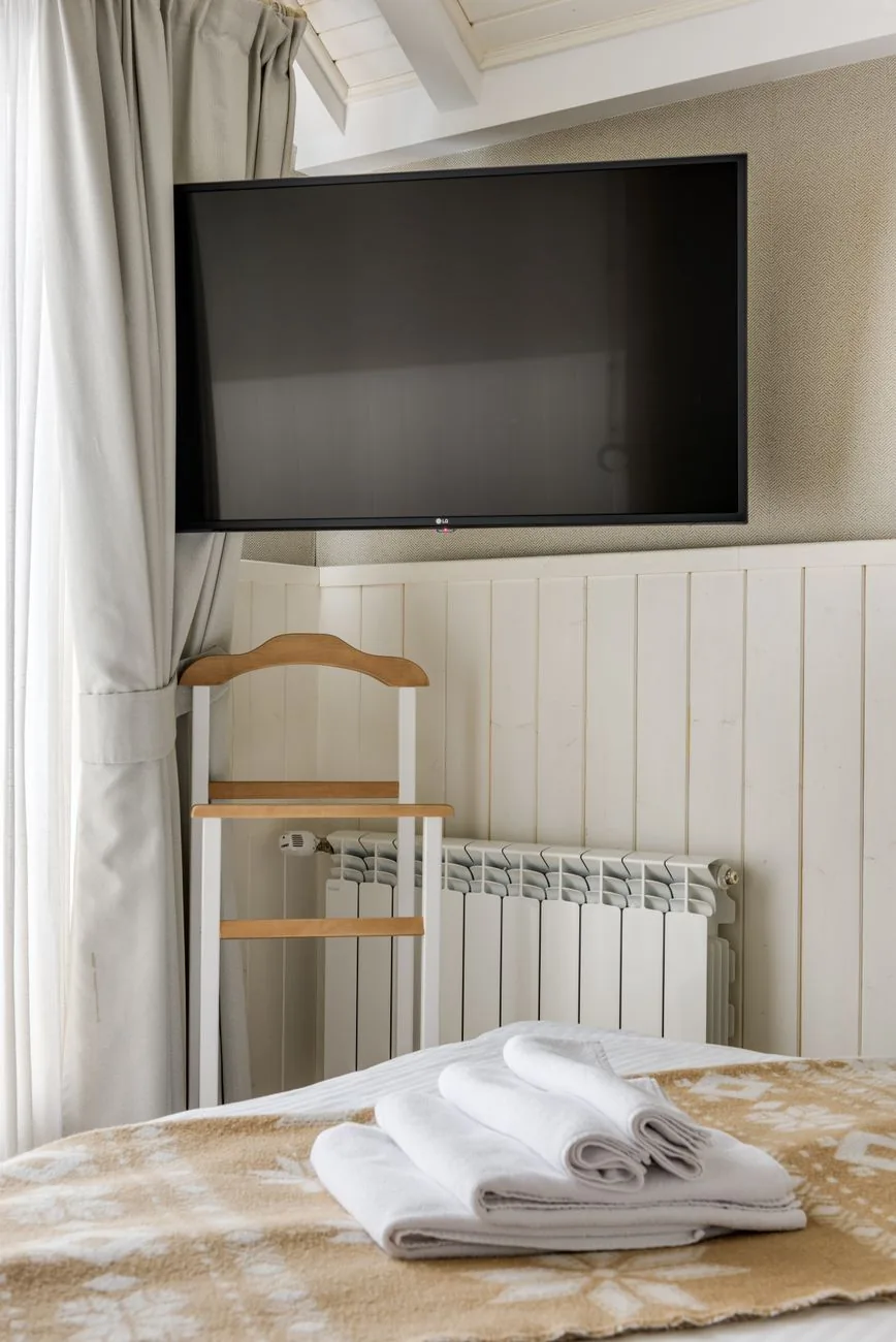 telewizor na ścianie w pokoju hotelowym — TCL C855 — czego przy tym sprzęcie nie zrobimy