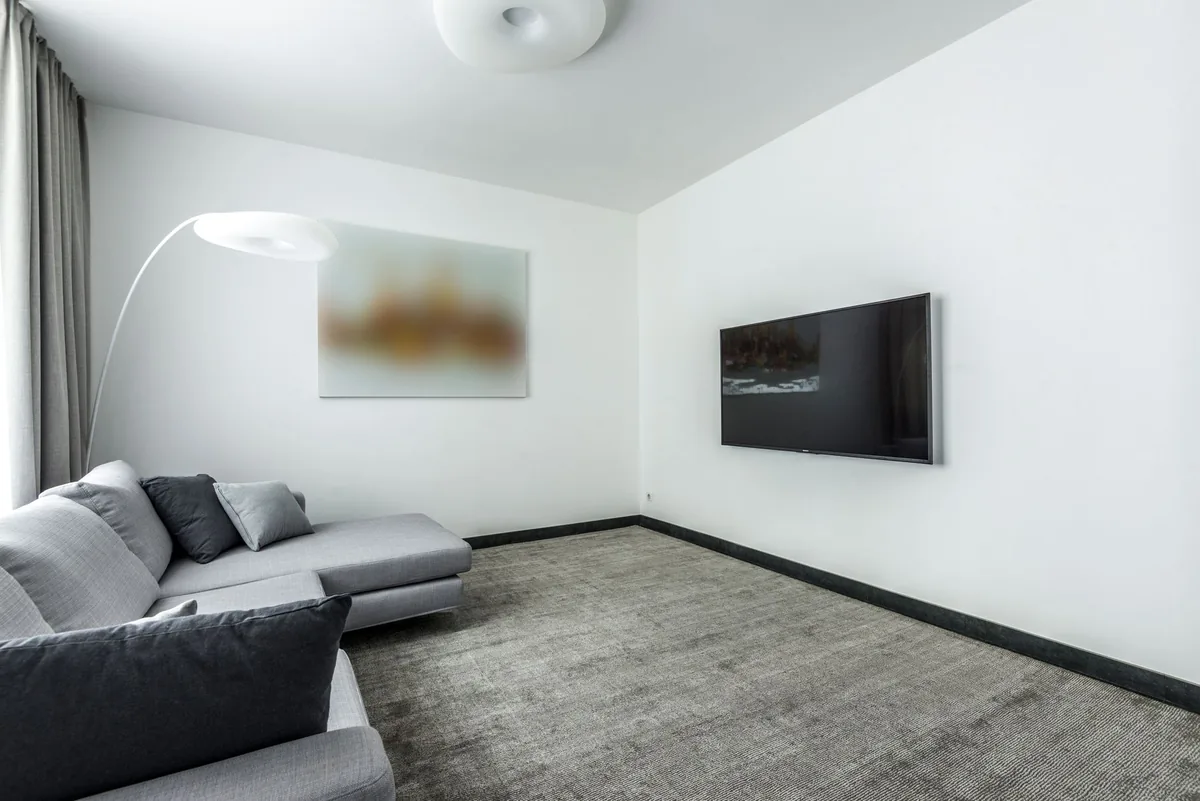 telewizor i szara sofa w minimalistycznym salonie — TCL P745 — czego przy tym sprzęcie nie zrobimy