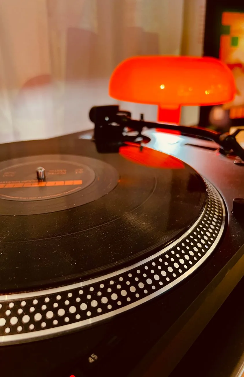 płyta winylowa na gramofonie obok pomarańczowej lampy — Technics SL-Q2 w zgłoszeniu — jak odpowiadamy i co radzimy