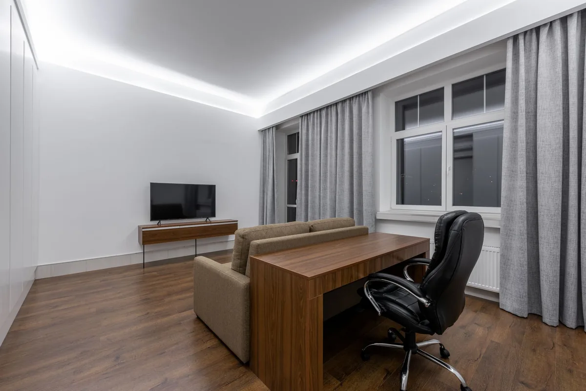 telewizor, sofa i drewniane biurko w minimalistycznym biurze — Thomson 43UG6400 poza naszym warsztatem — gdzie szukać pomocy