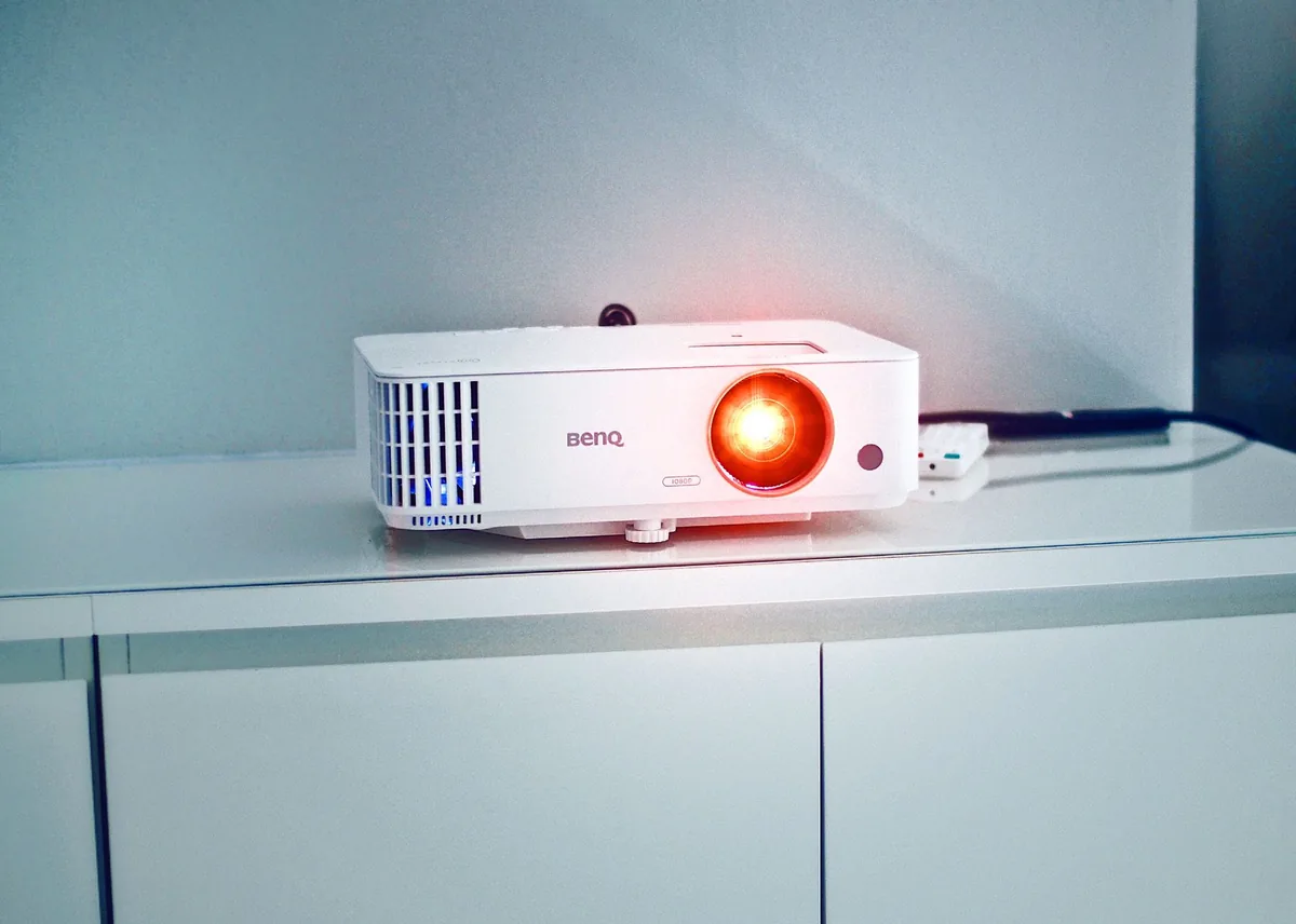 elegancki biały projektor stojący na szafce — ViewSonic PA503S a zakres naszego serwisu — czym zajmujemy się zamiast