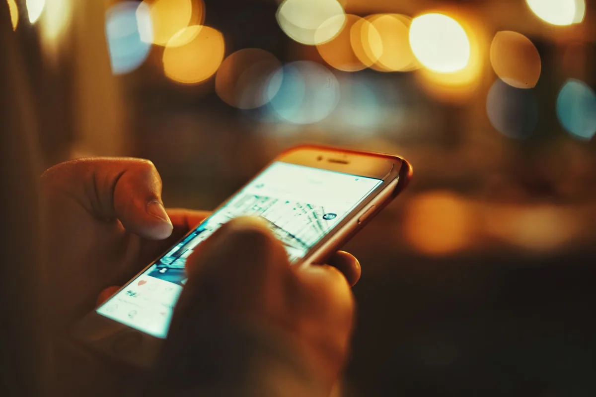 dłoń trzymająca telefon komórkowy na rozmytym tle — vivo V29 poza naszym warsztatem — gdzie szukać pomocy