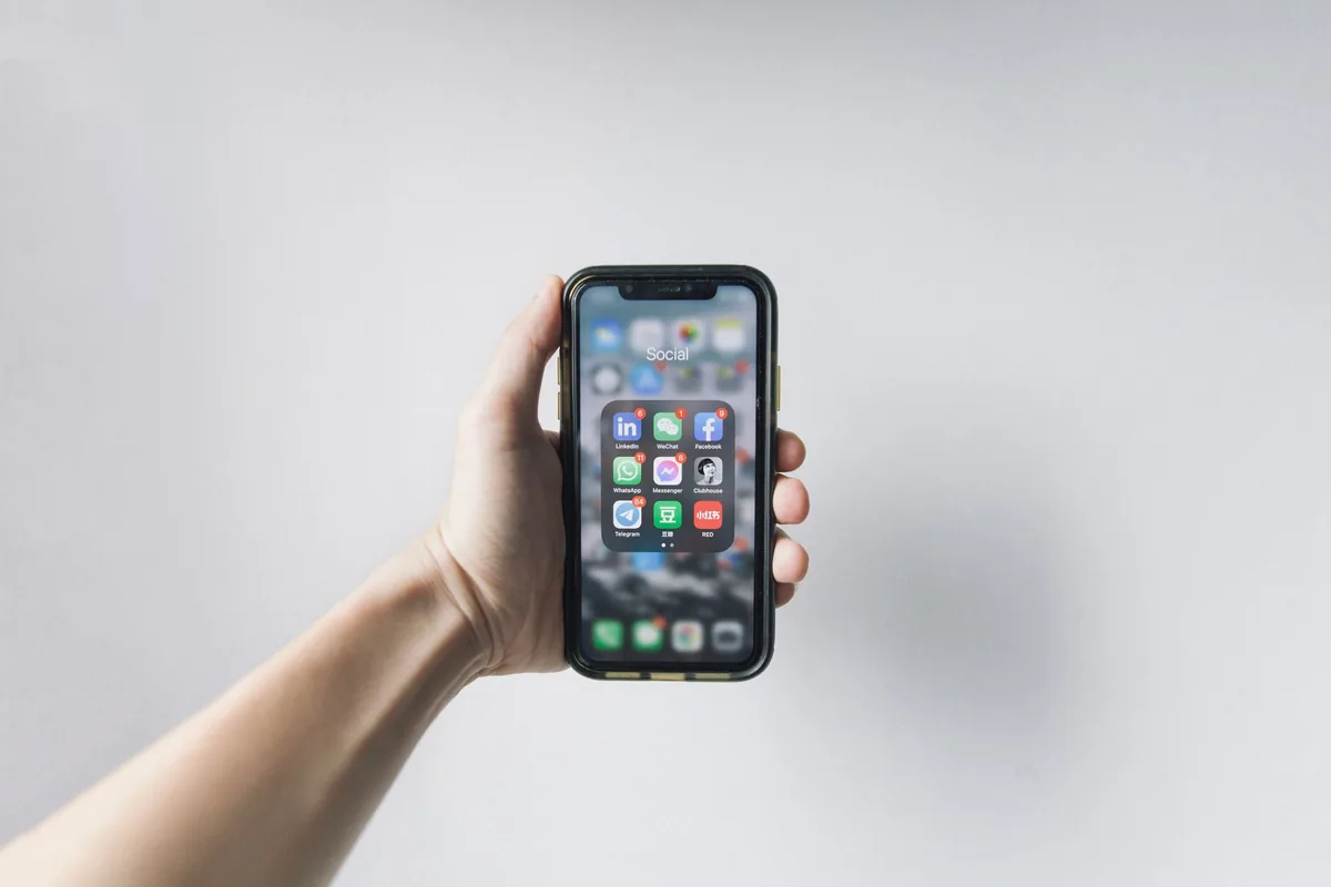 dłoń trzymająca smartfon z aplikacjami społecznościowymi — Xiaomi 13 a zakres naszego serwisu — czym zajmujemy się zamiast