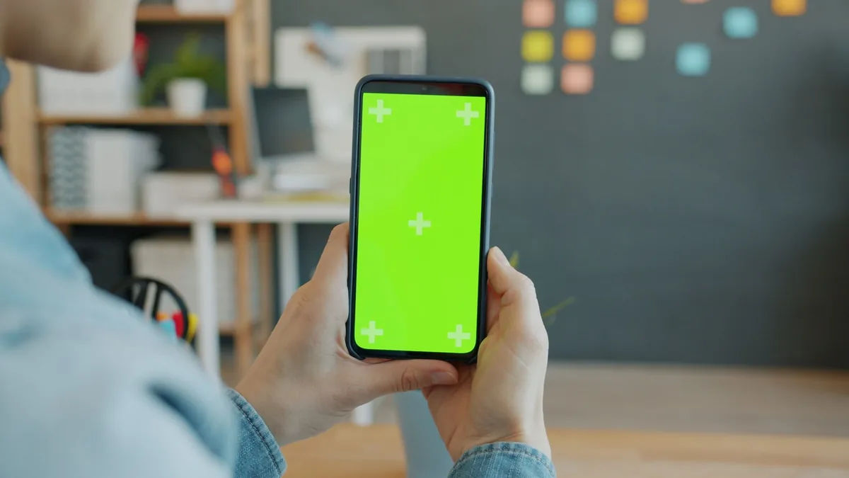 dłonie trzymające smartfon z zielonym ekranem — Xiaomi Mi Note 10 Lite poza naszym warsztatem — gdzie szukać pomocy