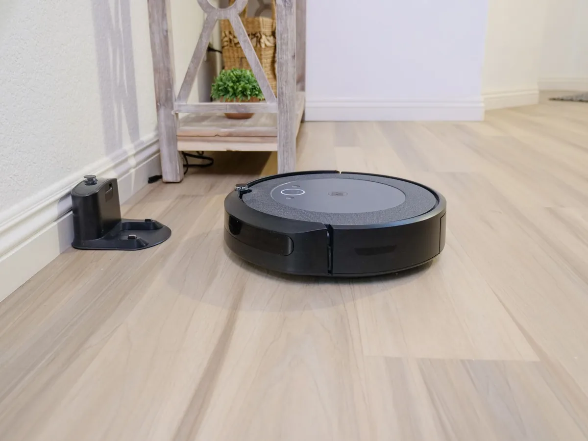 robot sprzątający na drewnianej podłodze przy stacji dokującej — Xiaomi Robot Vacuum S20+ poza naszym warsztatem — gdzie szukać pomocy