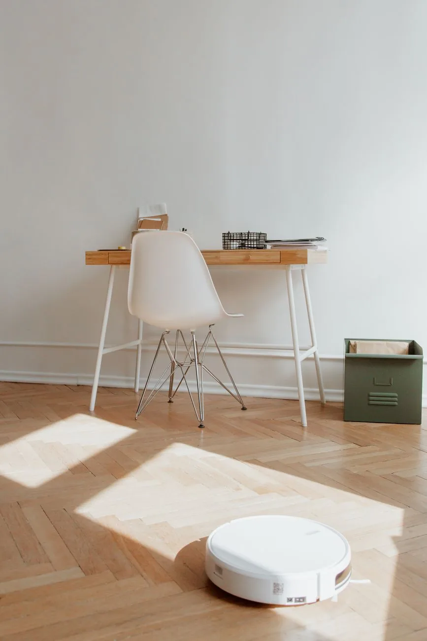 robot sprzątający na drewnianej podłodze pod biurkiem — Xiaomi Robot Vacuum X20 a zakres naszego serwisu — czym zajmujemy się zamiast