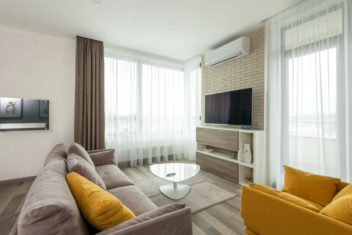 telewizor na ceglanej ścianie naprzeciwko sofy i fotela — Xiaomi TV A2 a zakres naszego serwisu — czym zajmujemy się zamiast