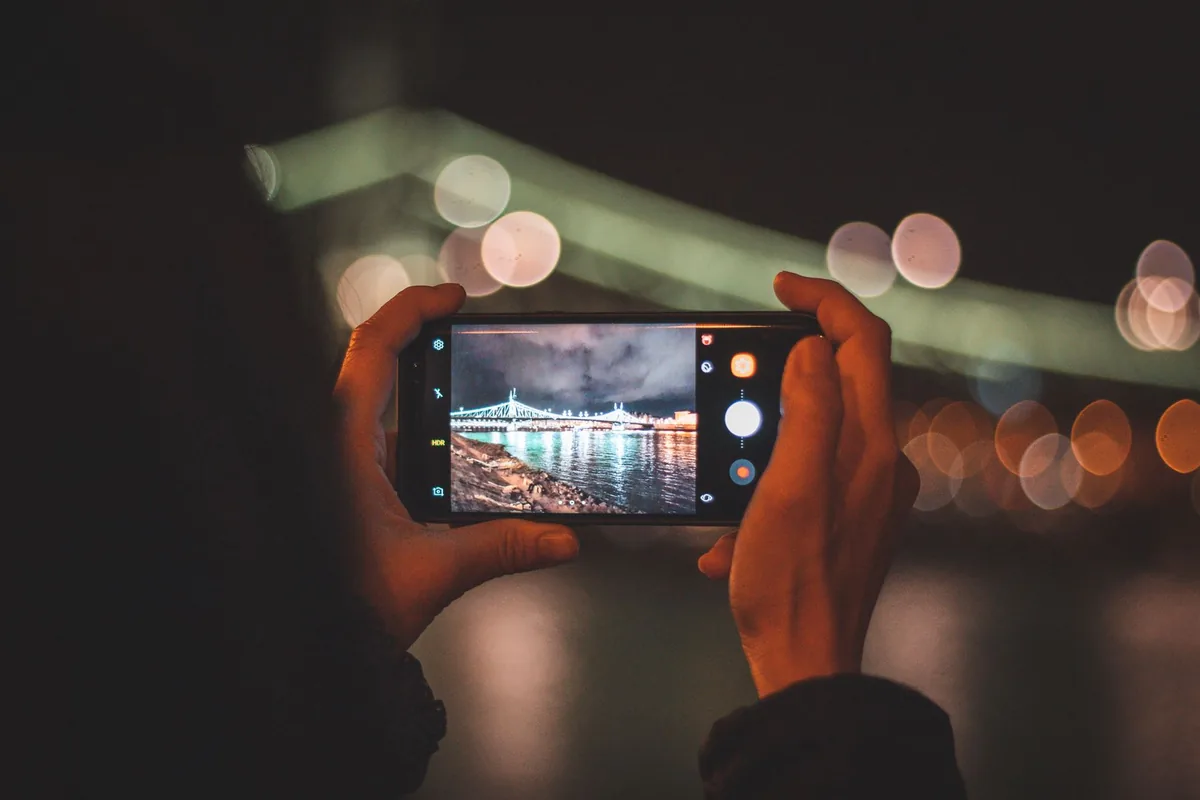 dłonie trzymające telefon na tle nocnego miasta — ZTE Blade A72 poza naszym warsztatem — gdzie szukać pomocy