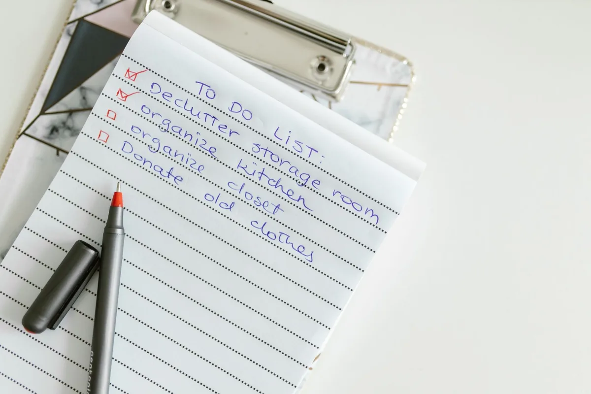A neatly written to-do list on lined paper with a pen, perfect for organizing tasks.